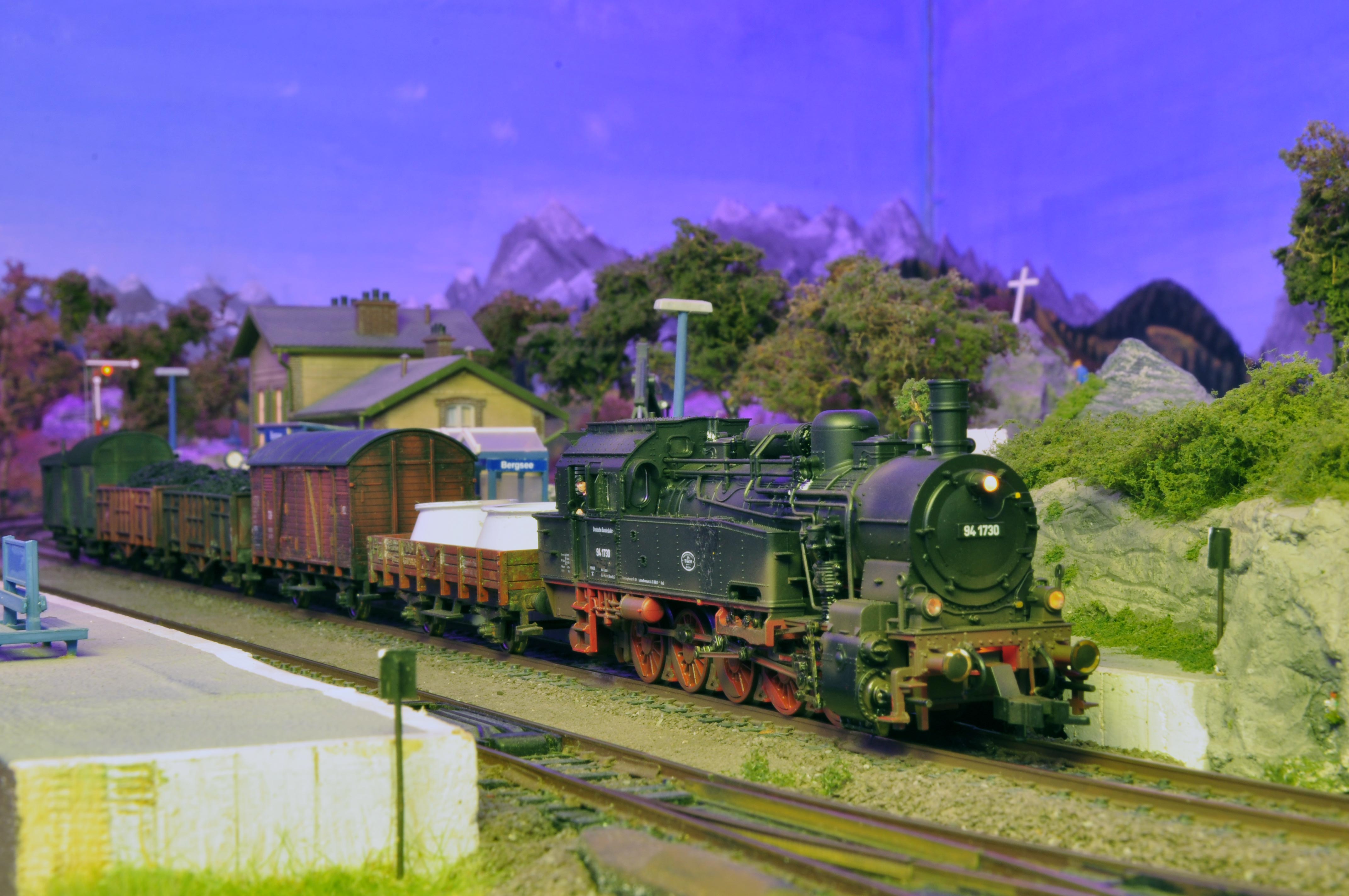 Die FLEISCHMANN 94 1730 steht mit einem gealterten Güterzug im Bahnhof in der ersten (fiktiven) Morgensonne.